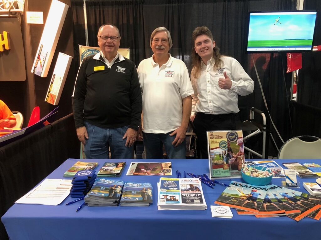 L-R District III VP Mark Radcliff, past VP Jim Martin, AMA Graphic Artist Hunter Saling manning the AMA Booth.